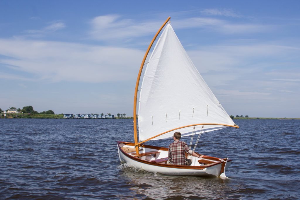 Houten zeilboot onder zeil op het water
