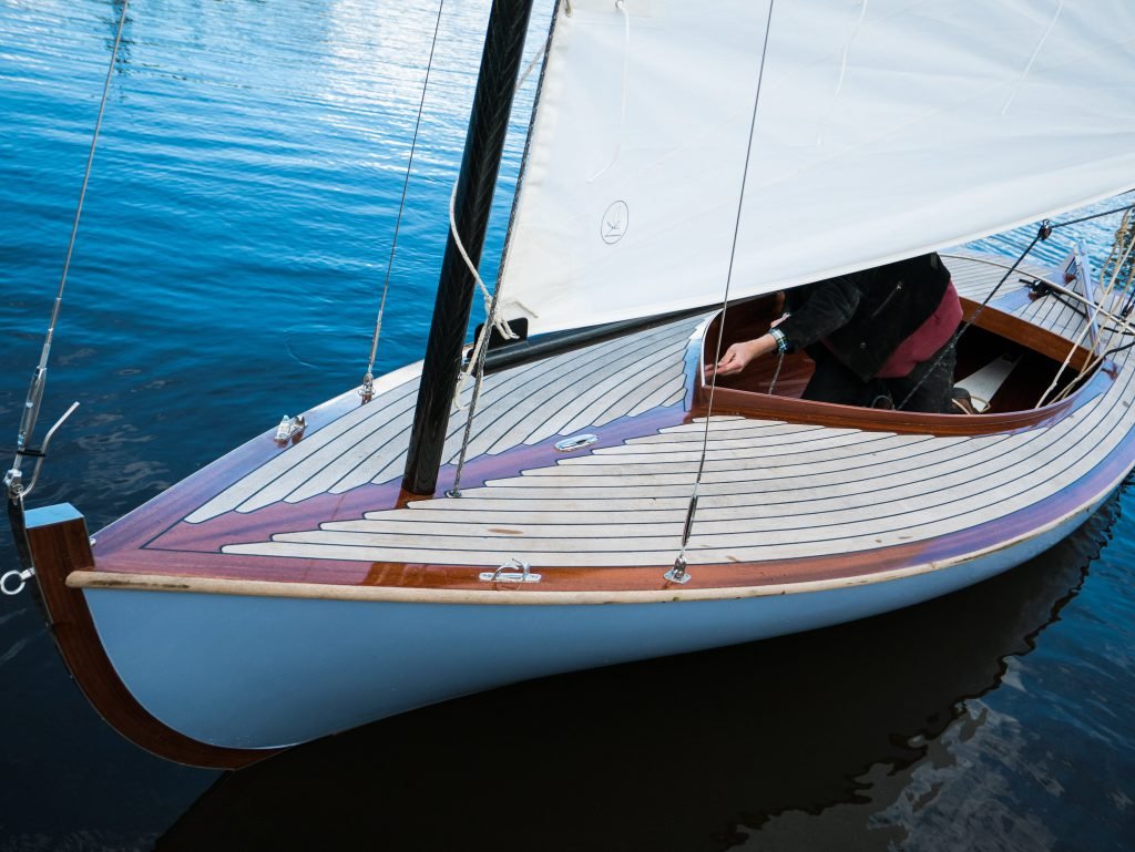 Houten zeilboot met teakdek, afgemeerd aan de steiger